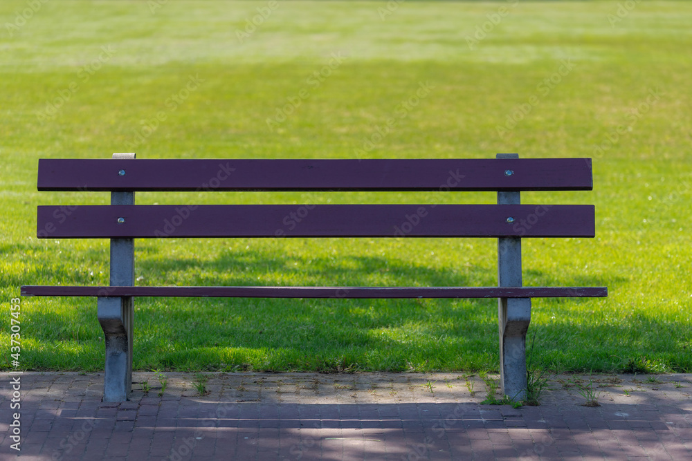 Alone and lonely concept, Outdoor park with empty bench under the shadow with soft sunlight in the afternoon, Wooden chair along the walkways with green meadow as background. Alone and lonely concept, Outdoor park with empty bench under the shadow with soft sunlight in the afternoon, Wooden chair along the walkways with green meadow as background.
