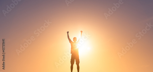 silhouette of man putting fist up in the air. People feeling strong, winning and victory concept. 