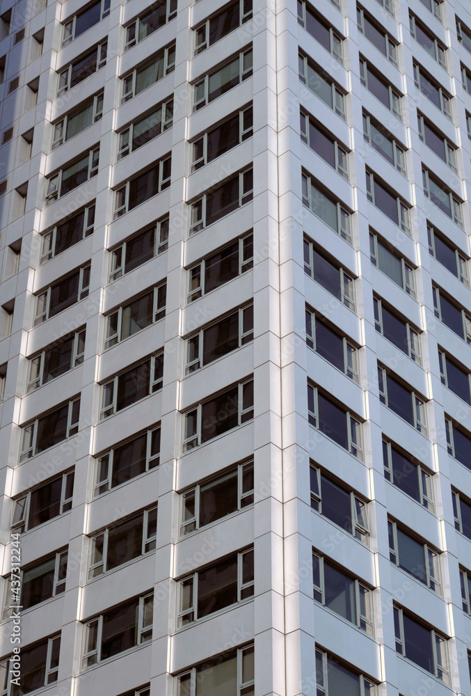 close up the corner of a modern apartment building with geometric metallic cladding and repeating pattern windows close up the corner of a modern apartment building with geometric metallic cladding and repeating pattern windows