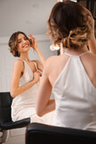 Woman with beautiful hairstyle near mirror in salon
