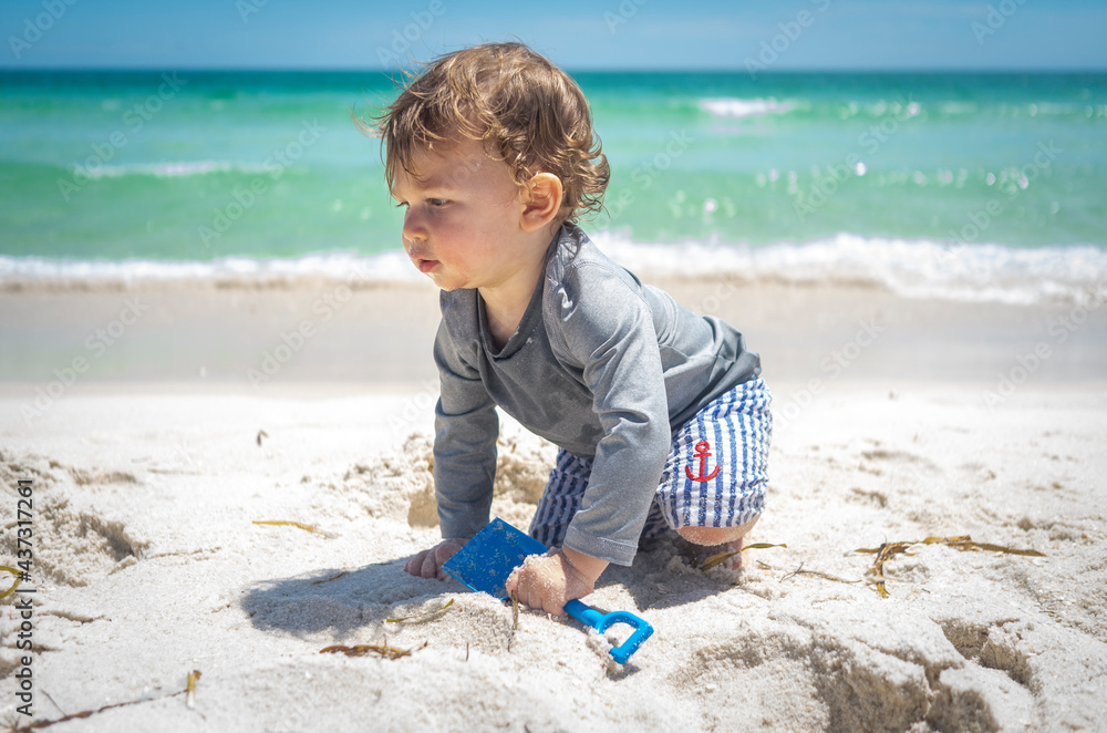 Baby beach adventure on family Florida road trip with white sand and blue ocean water crawling with sailor shorts and shovel Baby beach adventure on family Florida road trip with white sand and blue ocean water crawling with sailor shorts and shovel