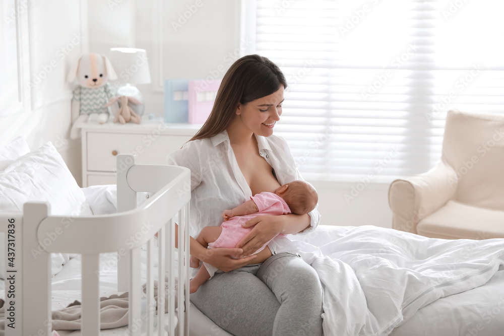 Happy young mother breastfeeding her newborn baby at home Happy young mother breastfeeding her newborn baby at home