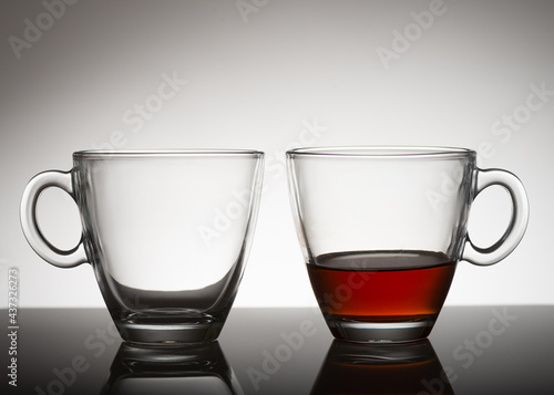 two classes: one is empty, the second one is half with tea 