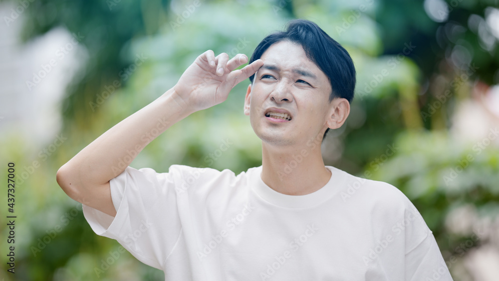 屋外で暑がる若い男性 屋外で暑がる若い男性