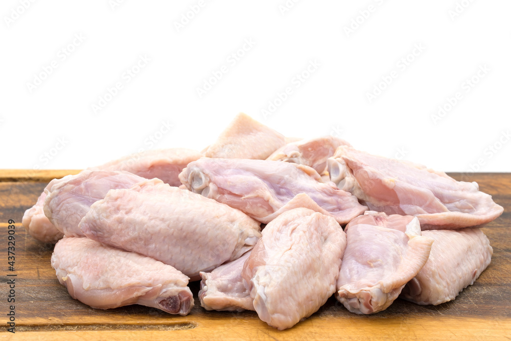 Fresh chicken wings on wooden board isolated on white background.