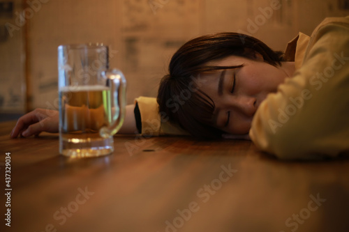 酒を飲み眠る女性