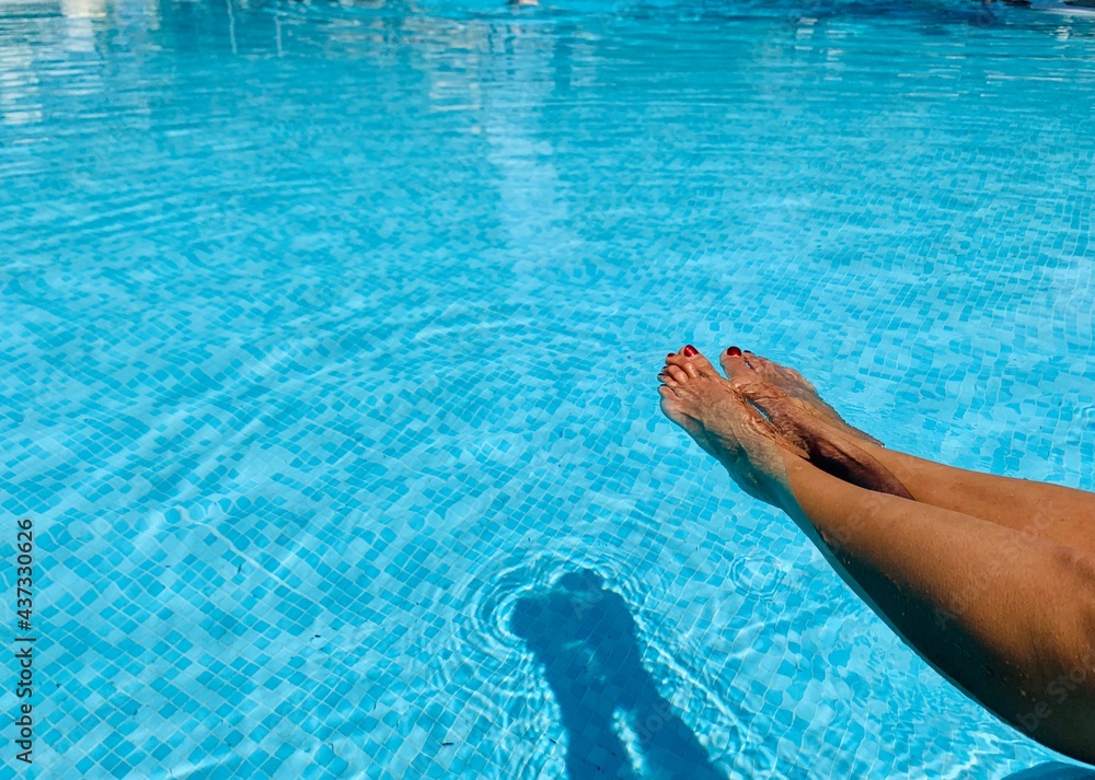 Female beautiful feet in pool