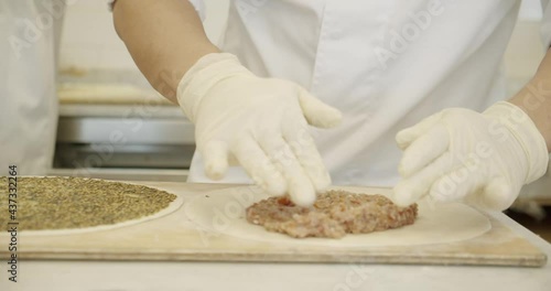 Adding Meat Toppings on Manakish flat bread dough or pizza photo