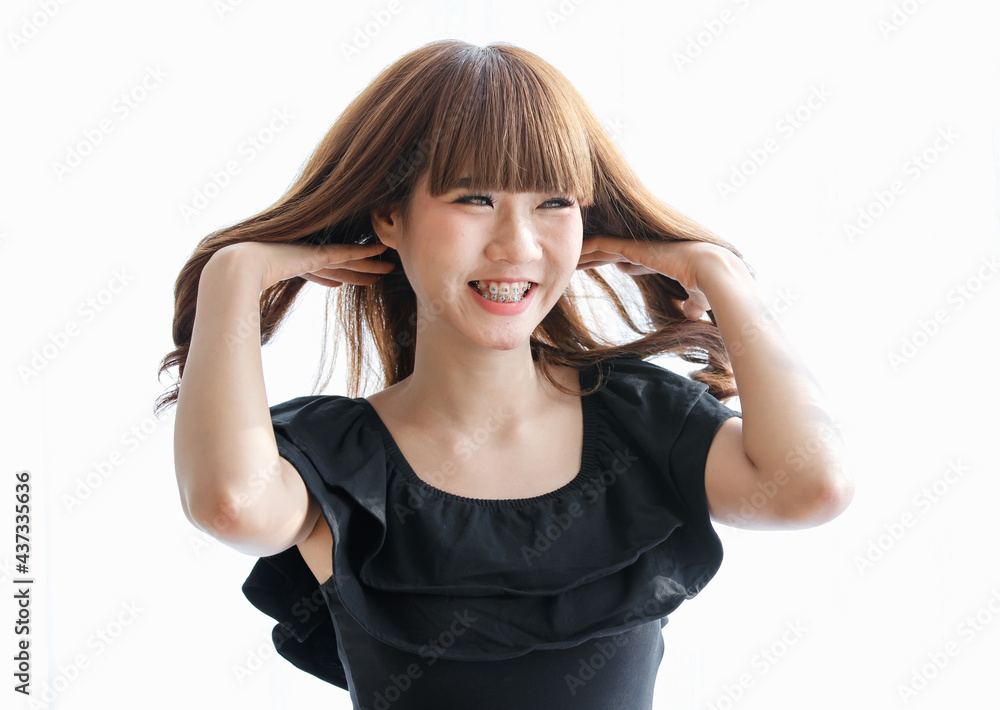 Lovely cute Asian woman in black dress using her hand to gather brunette hair and play on it with happy and funny for show her beautiful hairstyle Lovely cute Asian woman in black dress using her hand to gather brunette hair and play on it with happy and funny for show her beautiful hairstyle