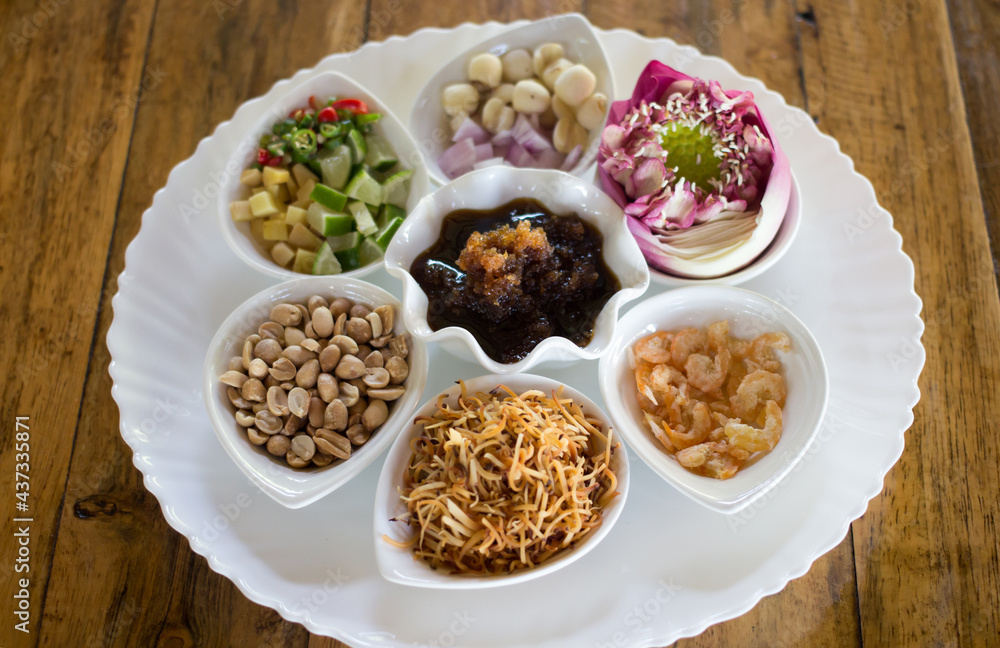 Miang Kham is a traditional Thai dessert. It is currently sold as street food. It involves wrapping several delicacy in lotus-petal leaves along with sweet, salty and spicy sauces. Miang Kham is a traditional Thai dessert. It is currently sold as street food. It involves wrapping several delicacy in lotus-petal leaves along with sweet, salty and spicy sauces.