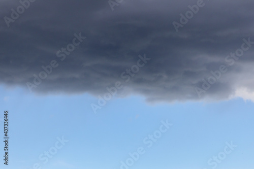 a blue sky with dark storm clouds. Rain clouds are gathering and a thunderstorm is coming. 