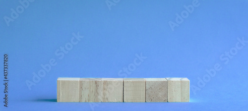 Fototapeta Naklejka Na Ścianę i Meble -  6 letter blank and wood blocks on table with blue background.