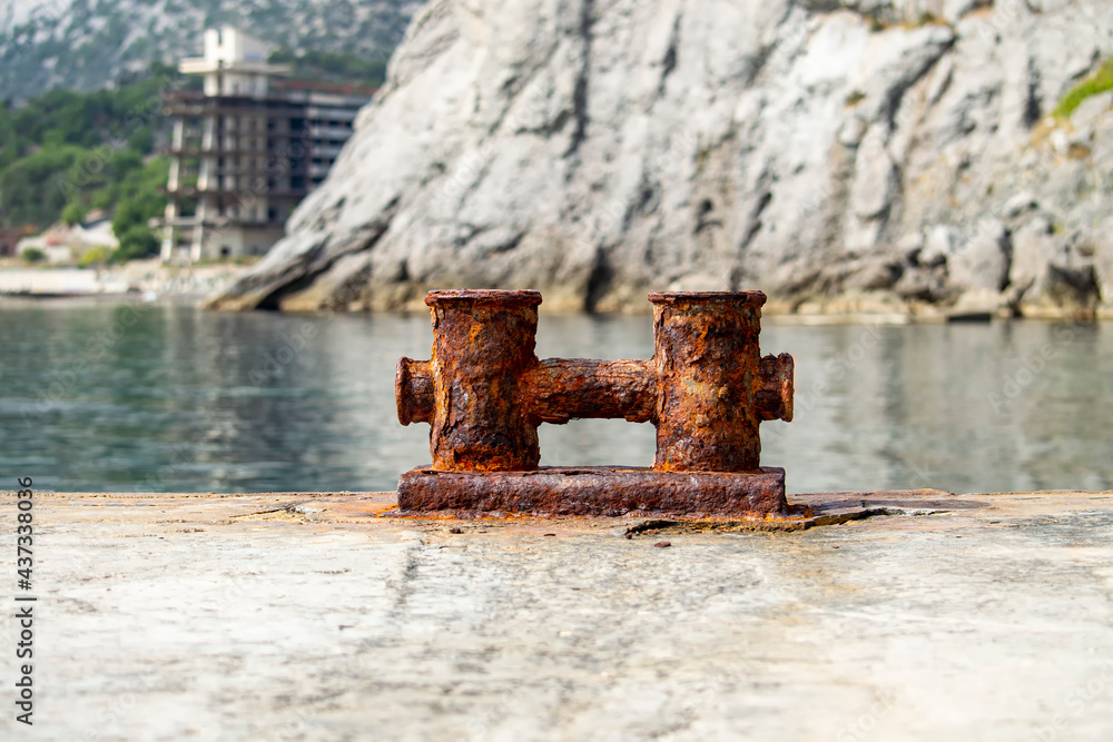 Fototapeta premium Knechts on pier against backdrop of sea and mountains and Abandoned hotel.