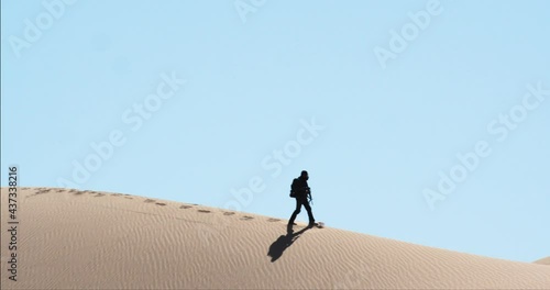 Beautiful cinematic silhouette of soldier walking through arid desert landscape, America