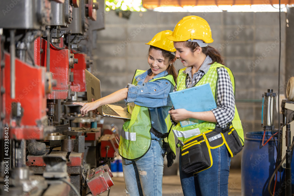 Asian engineering and worker woman in safety hard hat and reflective cloth using lathe machine inside the factory. A portrait of an industrial woman engineer with laptop in a factory, Asian engineering and worker woman in safety hard hat and reflective cloth using lathe machine inside the factory. A portrait of an industrial woman engineer with laptop in a factory,
