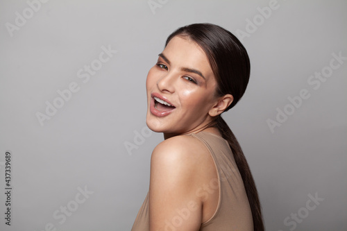 Happy young woman posing isolated on gray background