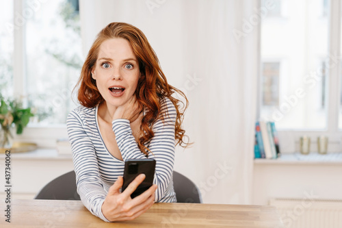 Принти на полотні Young woman staring at camera in shocked amazement