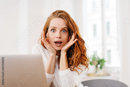 Shocked young woman staring aghast at the camera