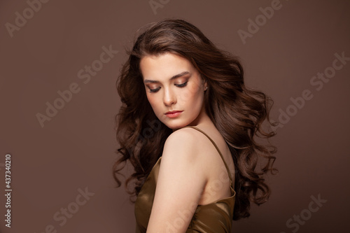 Portrait of woman with long curly beautiful dark hair. Healthy hair, salon care