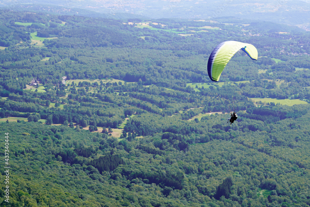 Paraglider in sky over volcano mountain the Puy de Dome France Paraglider in sky over volcano mountain the Puy de Dome France