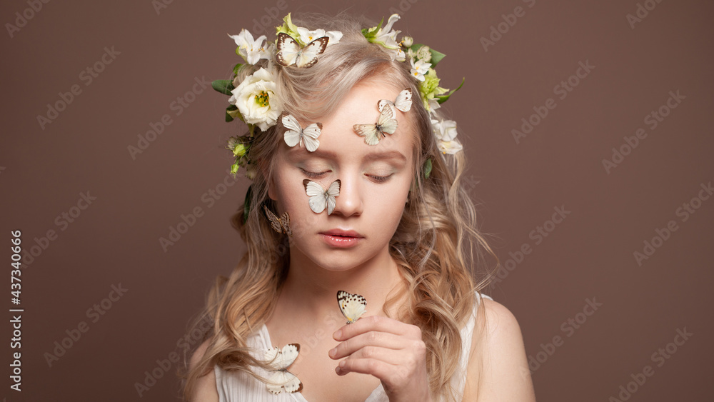 Portrait of young woman with butterflies standing on brown background. Nice woman with white butterflies and flowers