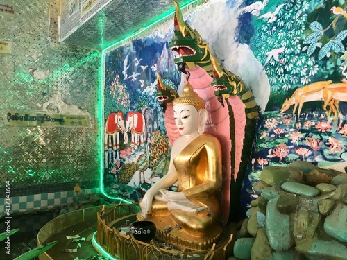 Buddha protected by the hood of the mythical serpent (Naga) at U Min Thonze temple in Sagaing city, Myanmar