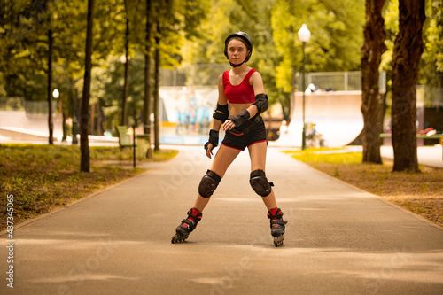 Roller skating girl kid in park rollerblading on inline skates. Caucasian young woman in outdoor activities.