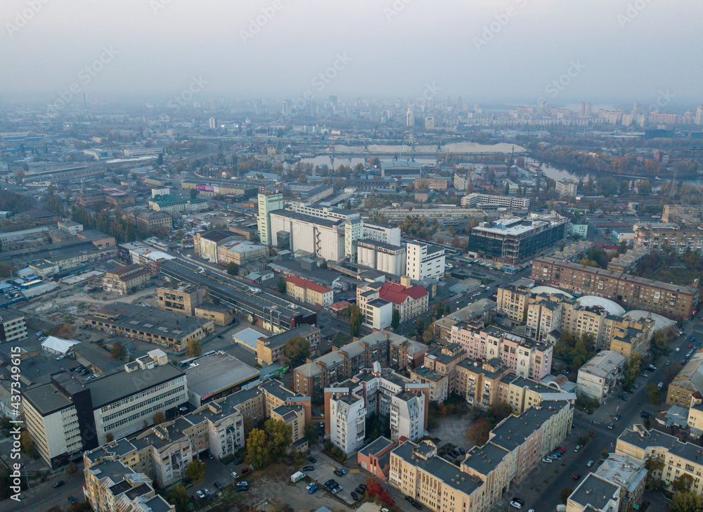 Aerial view of Kyiv city in at sunset. Podil historical district skyline from above. Grain elevator and abandoned factory, Ukraine