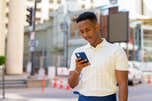 African businessman using mobile phone in the city streets
