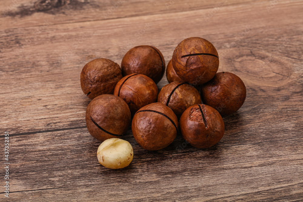 Brown macadamia nut heap over background Brown macadamia nut heap over background