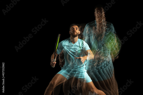 Stroboscope effect. One man, professional tennis player isolated on black background in mixed neon light. photo