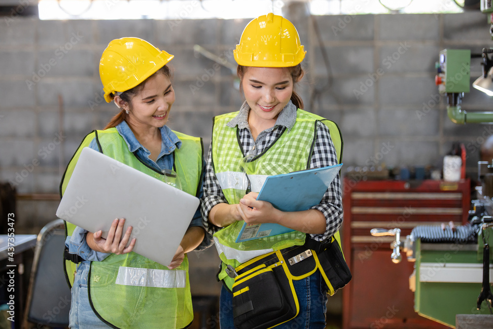 young woman asian workplace safety inspector writing a report at industrial factory. Two Asian female workers talked about industrial work young woman asian workplace safety inspector writing a report at industrial factory. Two Asian female workers talked about industrial work