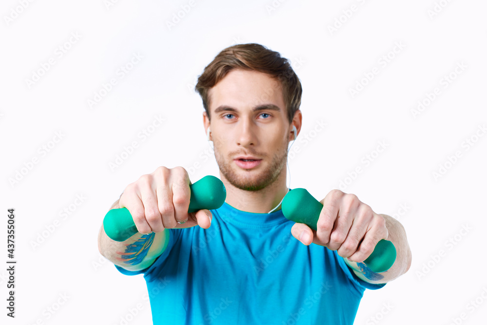 man with dumbbells in his hands blue t-shirt exercise fitness headphones man with dumbbells in his hands blue t-shirt exercise fitness headphones