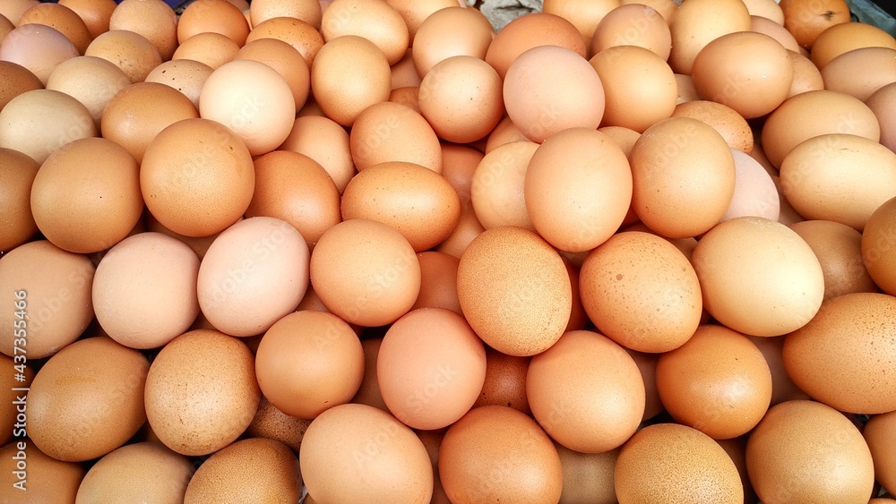 pile of domestic chicken eggs in a traditional Indonesian market. The color of the shell is dark brown with a relatively rough shell texture with a larger size. Staple food source of protein pile of domestic chicken eggs in a traditional Indonesian market. The color of the shell is dark brown with a relatively rough shell texture with a larger size. Staple food source of protein