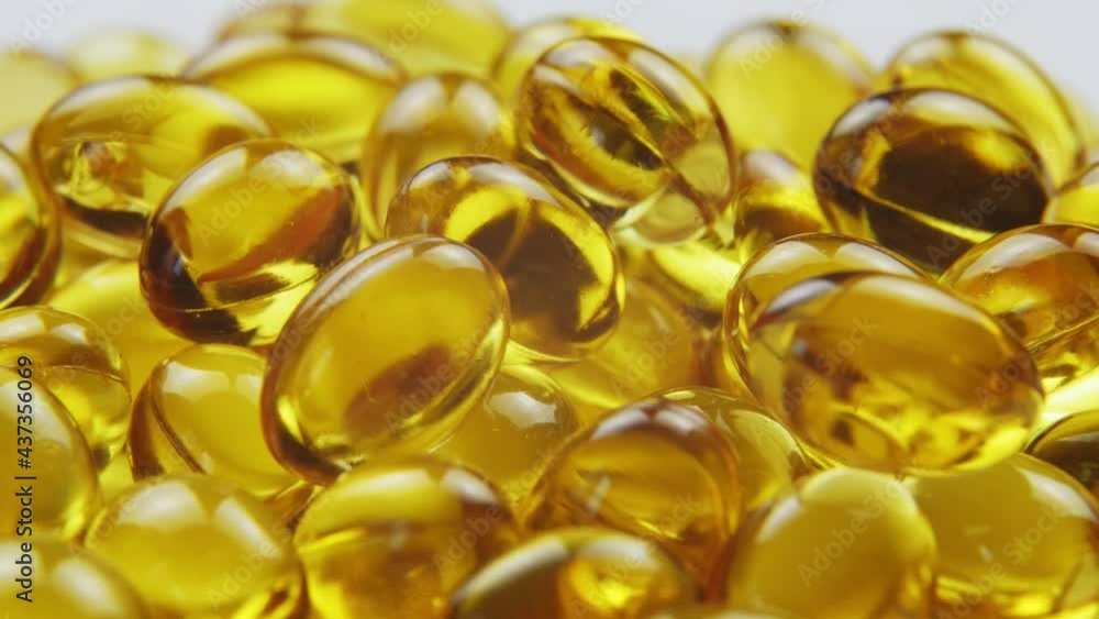 Macro view omega 3 gold fish oil capsules, rotation background Macro view omega 3 gold fish oil capsules, rotation background