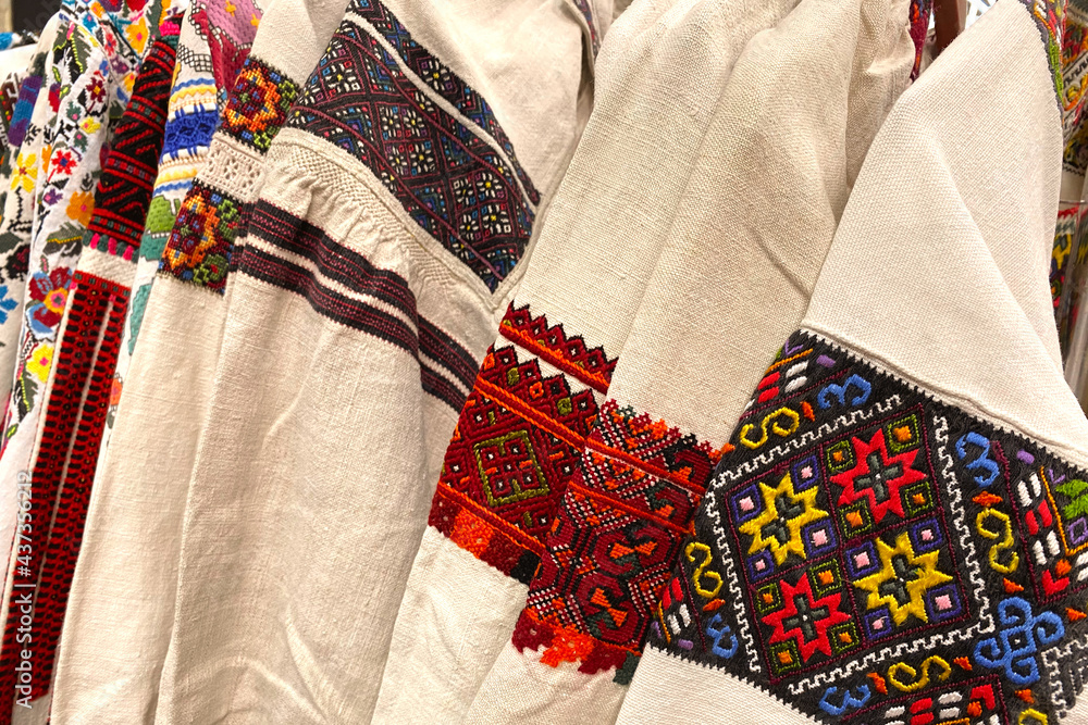 Different Ukrainian vintage clothes - traditional embroidered shirts, vyshyvanka. Secondhand goods on flea market, thrift shopping concept
