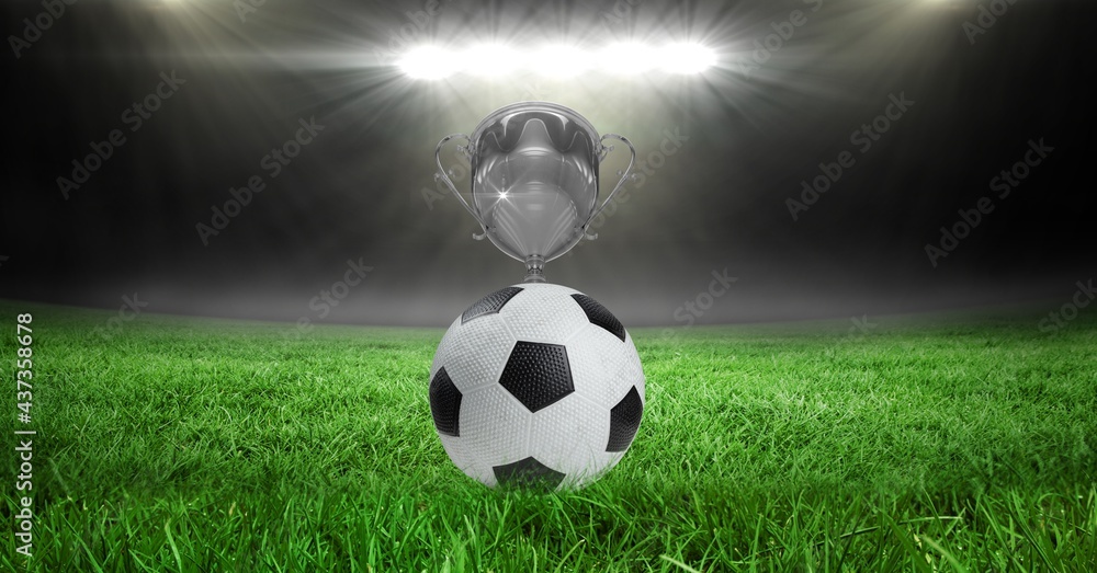 Compostion of cup and football over stadium and white blur