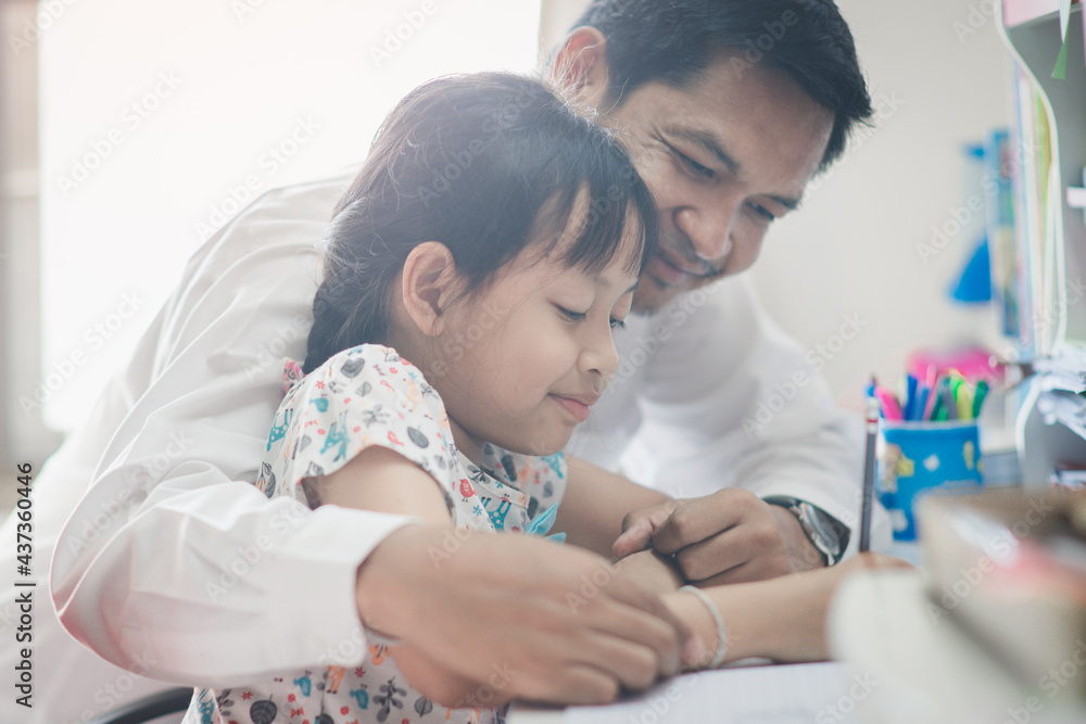Father helping daughter to homework with smile and happy at home.Concept of father day Father helping daughter to homework with smile and happy at home.Concept of father day