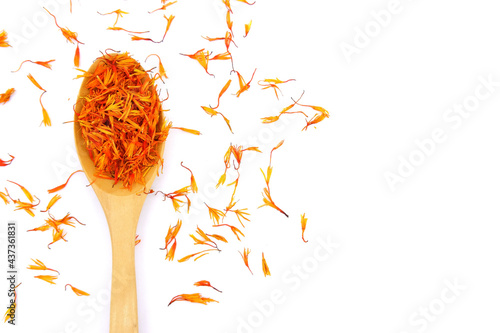 Photos A pile of Dried Safflower petals herb Tea and a wooden spoon
