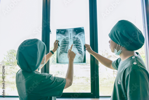 Doctor checking examining chest x-ray film of patient at ward hospital