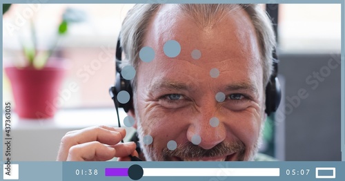 Composition of businessman talking on headset on video playback interface screen