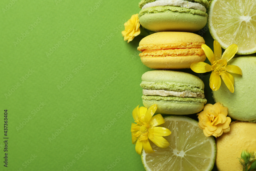 Macaroons, limes and flowers on green background Macaroons, limes and flowers on green background