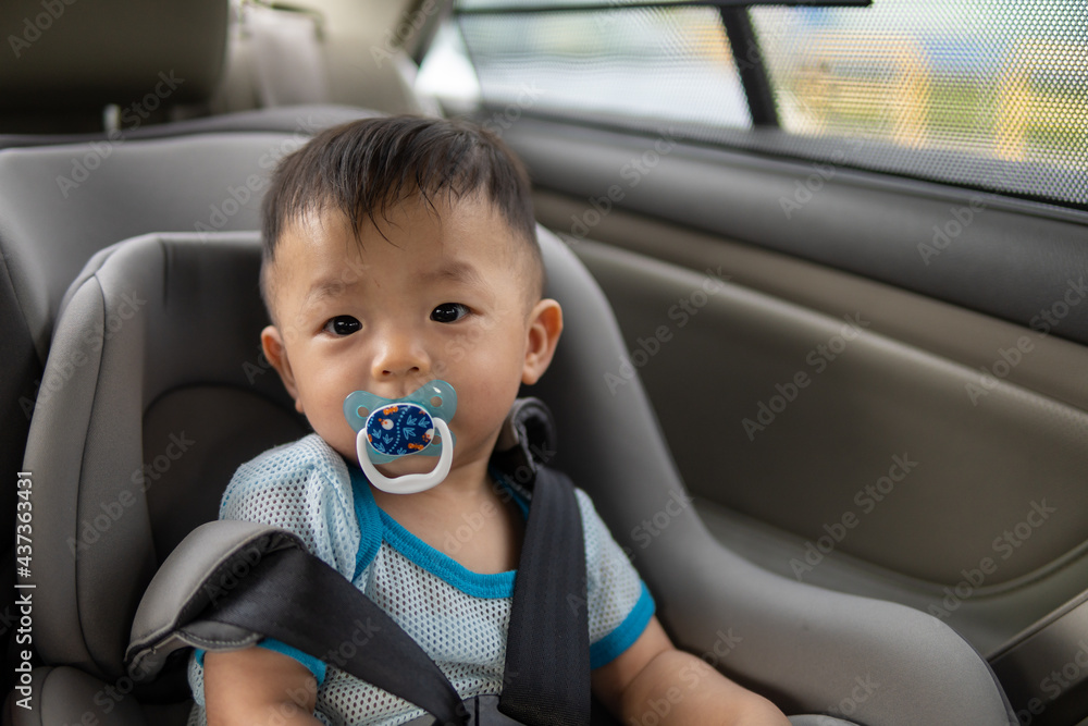 Local lifestyle Asian Chinese baby boy with emotion face and sucking pacifier while sit on child safety car seat Local lifestyle Asian Chinese baby boy with emotion face and sucking pacifier while sit on child safety car seat