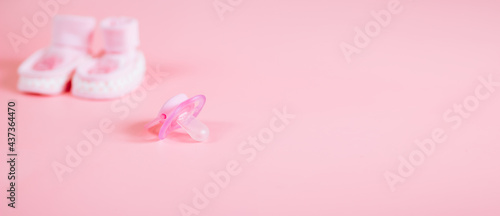 Orthodontic pacifier in pink color  isolated on a pink background. Shows signs of use. Space for text on a dummy background