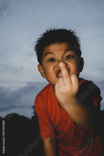 Portrait of angry boy showing middle fingers doing fuck you bad expression.