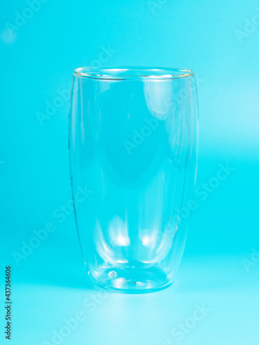 Empty glass with double walls on blue background