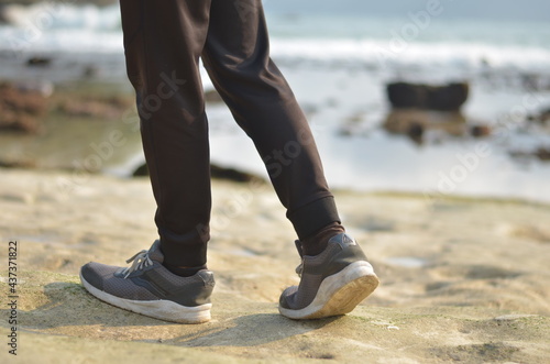 cropped male walking and relaxing on the beach with beach background blur
