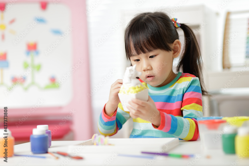 young girl painting money bank craft for homeschooling young girl painting money bank craft for homeschooling