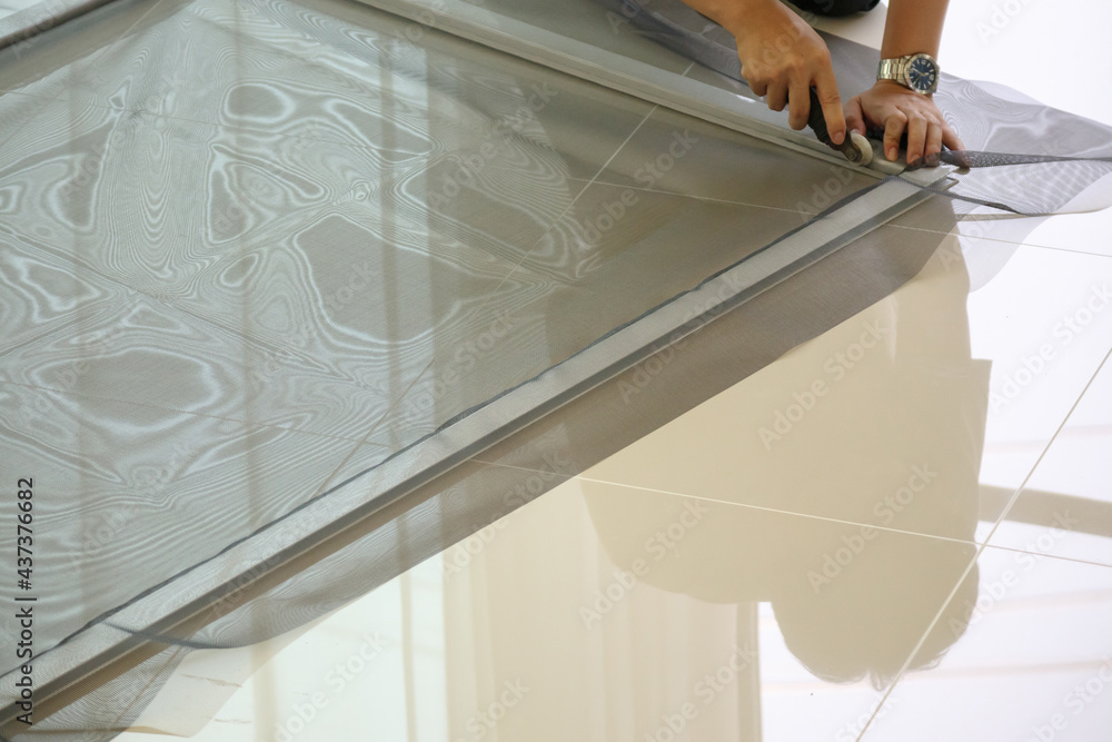 man install mosquito net wire screen on house window protection against insect man install mosquito net wire screen on house window protection against insect