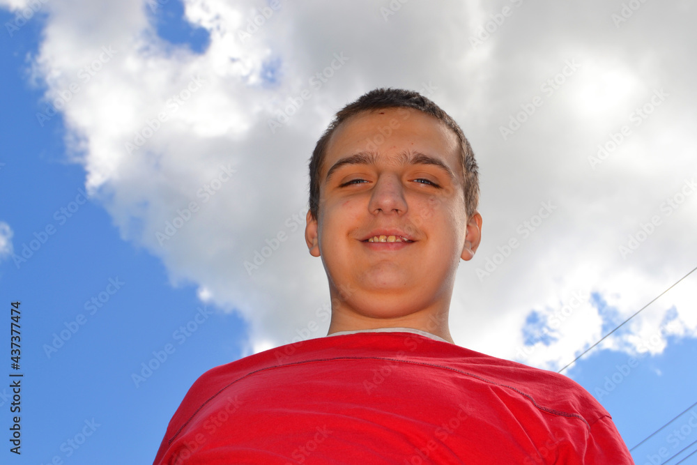 Fotografie Young happy autistic guy on blue sky background
